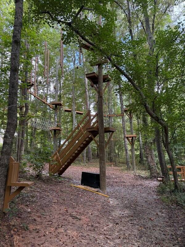 Wooden challenge course platform and elements in a wooded setting built by ARCL