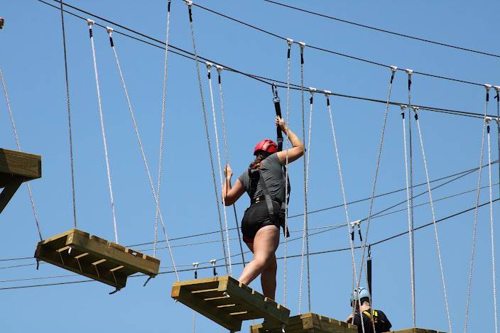 Participant navigating a high ropes challenge course